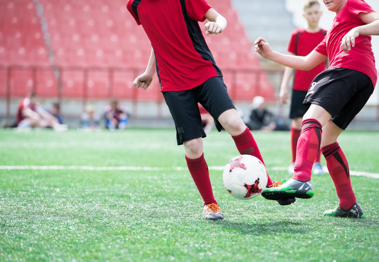 Unrecognizable Boy Kicking Ball at Football Practice